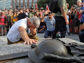 James Topp, a Canadian Forces reservist who marched across Canada protesting against COVID-19 vaccine mandates, touches the Tomb of the Unknown Soldier as he arrives at the National War Memorial ahead of Canada Day, in Ottawa, June 30, 2022.