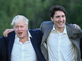 British Prime Minister Boris Johnson and Canadian Prime Minister Justin Trudeau have a laugh during a leaders group photo during the G7 Summit at Elmau Castle, Germany on June 26, 2022.