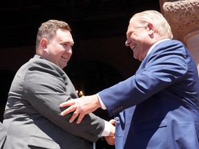 Der Minister für Staatsbürgerschaft und Multikulturalismus von New Ontario, Michael Ford, schüttelt seinem Onkel Premier Doug Ford bei einer Vereidigungszeremonie im Queen's Park in Toronto am 24. Juni 2022 die Hand.