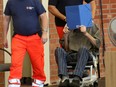 Former Nazi concentration camp guard Josef Schuetz (R) hides his face with a folder as he arrives on June 28, 2022 at a gym used as a makeshift courtroom in Brandenburg an der Havel, eastern Germany, where his verdict was spoken. The 101-year-old man is the oldest person so far to be charged with complicity in war crimes during the Holocaust.