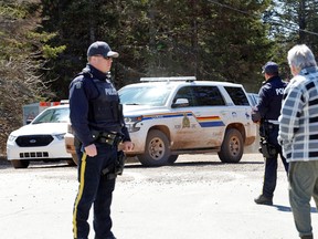 An RCMP officer speaks with a man after police finished their search for mass shooter Gabriel Wortman, in Portapique, Nova Scotia, April 19, 2020.