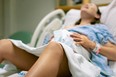 A woman screaming in pain from strong contractions. Childbirth.