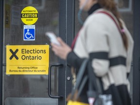 A pedestrian walks past an Elections Ontario voting location in Toronto, Wednesday May 25, 2022.
