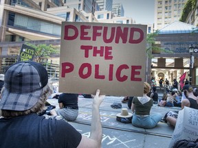 People protest for the Black Lives Matter movement out front of the Toronto Police Headquarters on College Street during the Covid 19 pandemic,  Friday June 19, 2020.