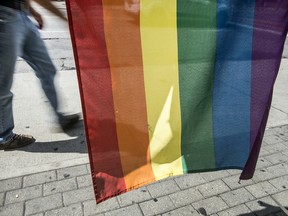 File: A pedestrian walks past the Pride flag on Church Street in ”The Village", Toronto's predominantly gay neighbourhood.