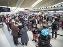 Travellers wait in line at Toronto Pearson Airport's Terminal 1, May 9, 2022.