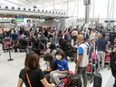 Reisende warten am Terminal 1 des Flughafens Toronto Pearson in der Schlange.