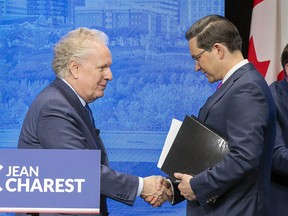Jean Charest and Pierre Poilievre at the leadership debate in Edmonton. Charest’s supporters question the claim Poilievre has sold 25,000 memberships in Quebec.