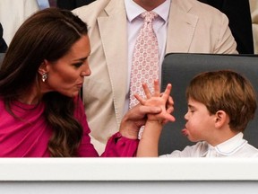 Britain's Catherine, Duchess of Cambridge, restrains her son Prince Louis of Cambridge (R) during the Platinum Pageant in London on June 5, 2022.