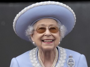 Queen Elizabeth II, on the balcony of Buckingham Palace, watches an RAF flypast during the Trooping the Colour parade to mark the 70th anniversary of the Queen's accession to the throne, June 2, 2022.