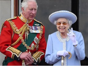 Queen Elizabeth stands with Prince Charles to watch a special flypast from a Buckingham Palace balcony during Platinum Jubilee celebrations, in London on June 2, 2022.
