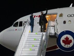 Premier Justin Trudeau zwaait terwijl hij uit een regeringsvliegtuig stapt in Berlijn, Duitsland, 8 maart 2022. The Canadian Press / Adrian Wilde