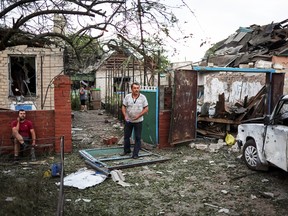 Residents stand near their building that was destroyed by a Russian missile strike in the town of Pokrovsk, in Donetsk region, Ukraine June 15, 2022.