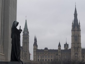 The statue representing justice looks out from the Supreme Court of Canada over the Parliamentary precinct in Ottawa on Thursday March 25, 2021. Canada's top court has sent the case of two men convicted in the slayings of three family members back to the Alberta Court of Appeal.