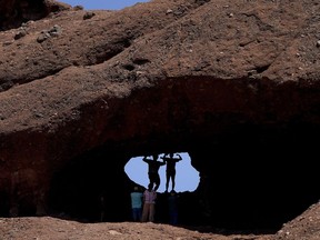 A pair of mid-day hikers pose for a picture in the hole in the rock at Papago Park, Friday, June 10, 2022, in Phoenix. Heat is part of the normal routine of summertime in the desert, but weather forecasters say that doesn't mean people should feel at ease. Excessive heat causes more deaths in the U.S. than other weather-related disasters, including hurricanes, floods and tornadoes combined. Officials are advising people to limit time outdoors, drink plenty of water and seek shade if they must be outside.