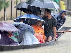 People get on a boat as they look for shelter during a flood, amidst heavy rains that caused widespread flooding in the northeastern part of the country, in Sylhet, Bangladesh, June 18.