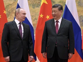 FILE - Chinese President Xi Jinping, right, and Russian President Vladimir Putin talk to each other during their meeting in Beijing, China, Friday, Feb. 4, 2022. Xi has reasserted his country's support for Russia on "issues concerning core interests and major concerns such as sovereignty and security," in a phone call with Russian leader Vladimir Putin, Wednesday, June 15, 2022.