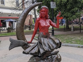 This image provided by Daniel Fury shows the "Bewitched" statue partially covered with red paint, Monday, June 6, 2022, in Salem, Mass. Witnesses called police Monday to report someone spray painting the bronze statue, police said. The statue depicts actor Elizabeth Montgomery as lead character Samantha Stephens in the 1960s sitcom sitting on a broomstick in front of a crescent moon.