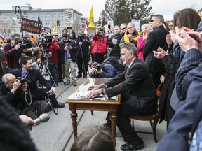 FILE - Vermont Republican Gov. Phil Scott finishes signing a gun restrictions bill on the steps of the Statehouse, April 11, 2018, in Montpelier, Vt. In a letter sent to the nation's 100 senators and released Tuesday, June 21, 2022, to The Associated Press, Scott said efforts to reduce gun violence can't just focus on guns. The senators, he wrote, have the chance to work together to make a real difference.