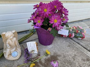 A memorial, shown on June 8, 2022, in the back alley of a home in Calgary where an 86-year-old woman was attacked by dogs. She was taken to hospital and later died.