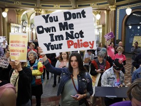 FILE - Marissa Messinger, of Lake View, Iowa, center, holds a sign during a rally to protest recent abortion bans, May 21, 2019, at the Statehouse in Des Moines, Iowa. The Iowa Supreme Court on Friday, June 17, 2022, cleared the way for lawmakers to severely limit or even ban abortion in the state, reversing a decision by the court just four years ago that guaranteed the right to the procedure under the Iowa Constitution.