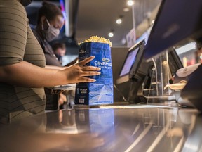 Customers buy popcorn at a Cineplex theatre in downtown Toronto on Wednesday, Aug. 26, 2020. ;Cineplex Inc. says it's started charging a $1.50 per ticket booking fee for purchases made through its mobile app and website.