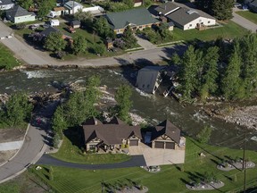 FILE - A house sits in Rock Creek after floodwaters washed away a road and a bridge in Red Lodge, Mont., in Red Lodge, Mont., June 16, 2022.