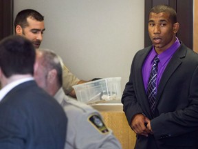 Former Canadian Football League wide receiver Joshua Boden, right, goes through security screening as he arrives at British Columbia Provincial Court in Vancouver, B.C., on Thursday July 26, 2012. A former Canadian Football League wide receiver convicted of killing his ex-girlfriend is expected to be sentenced in B.C. Supreme Court today.