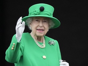 Queen Elizabeth II waves to the crowd during the Platinum Jubilee Pageant at the Buckingham Palace in London, Sunday, June 5, 2022, on the last of four days of celebrations to mark the Platinum Jubilee.