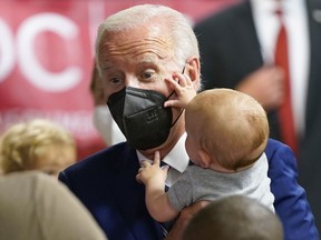 President Joe Biden holds a baby as he visits a COVID-19 vaccination clinic at the Church of the Holy Communion Tuesday, June 21, 2022, in Washington.