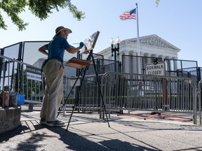 Artist Elaine Wilson works on a painting of the Supreme Court, Wednesday, June 29, 2022, in Washington.