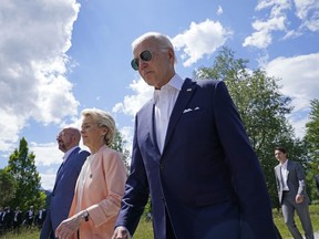 President Joe Biden, right, walks with European Commission President Ursula von der Leyen, center, and European Council President Charles Michel, left, as they head to a family photo with the G7 leaders at the G7 Summit in Elmau, Germany, Sunday, June 26, 2022.
