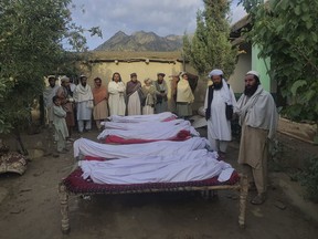 Men stand around the bodies of people killed in an earthquake in Gayan village, in Paktika province, Afghanistan, Wednesday, June 22, 2022. A powerful earthquake struck a rugged, mountainous region of eastern Afghanistan early Wednesday, flattening stone and mud-brick homes in the country's deadliest quake in two decades, the state-run news agency reported.