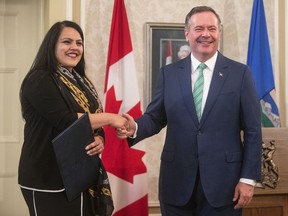 Rajan Sawhney shakes hands with Alberta Premier Jason Kenney after being appointed minister of transportation during a cabinet shuffle a Government House in Edmonton on Thursday, July 8, 2021. Sawhney says she is running to replace Jason Kenney as United Conservative leader and Alberta premier.