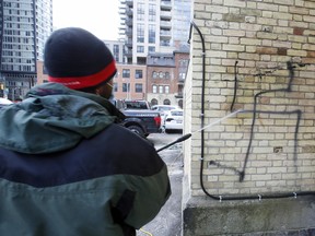 A worker removes anti-Semitic graffiti from a Toronto church in March. A new House of Commons report on ideologically-motivated violent extremism said the narratives that are used to draw individuals in and radicalize them include “anti-authority; Islamophobia, anti-Semitism, and other forms of religious intolerance; racism; misogyny; and anti-LGBTQ2SI.”