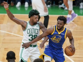Golden State Warriors forward Andrew Wiggins (22) drives against Boston Celtics guard Marcus Smart (36) during the first quarter of Game 6 of basketball's NBA Finals, Thursday, June 16, 2022, in Boston.