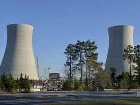 FILE - The cooling towers of the still under construction Plant Vogtle nuclear energy facility in Waynesboro, Ga., Friday, March 22, 2019.  One of the owners of the plant announced Saturday, June 18, 2022, that it was freezing its costs and forcing Georgia Power Co. to assume all future overruns, giving up a share of its ownership to Georgia Power.