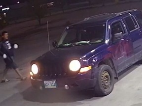 A man is seen approaching a blue 2012 Jeep Patriot in an undated police handout photo. Police say a woman with dementia who was allegedly abducted while the Jeep was parked at a gas station has been found safe.