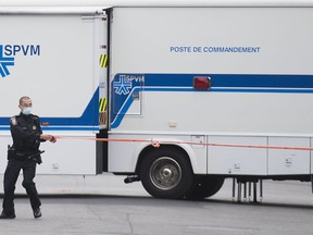 A police officer uses tape to close off a street next to a command post vehicle in Montreal North, Sunday, Oct. 4, 2020.&ampnbsp;Montreal police say a man has died Friday night in what they describe as a family dispute with his son.