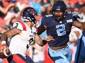 Montreal Alouettes quarterback Vernon Adams Jr (3) scrambles before getting sacked by Toronto Argonauts' Shawn Oakman (2) during first half CFL football action in Toronto Thursday, June 16, 2022.