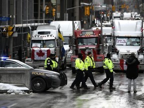 Police officers patrol on foot along Albert Street as a protest against COVID-19 restrictions that has been marked by gridlock and the sound of truck horns reaches its 14th day, in Ottawa, Thursday, Feb. 10, 2022.&ampnbsp;The Ontario police watchdog says two Vancouver police officers did not commit a criminal offence by shooting non-lethal rounds at two protesters during the 'freedom convoy' protest in February.