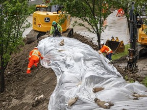 Workers installed a temporary berm along Memorial Drive as heavy rainfall in southern Alberta prompted the city of Calgary to declare a local state of emergency, in Calgary, Alta., Tuesday, June 14, 2022.THE CANADIAN PRESS/Jeff McIntosh