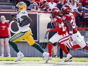 Edmonton Elks receiver Emmanuel Arceneaux, left, runs in a touchdown as Calgary Stampeders defensive back Dionte Ruffin, centre, and defensive back Titus Wall chase him during first half CFL football action in Calgary, Saturday, June 25, 2022.