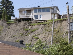 A house remains standing after a landslide destroyed a house and forced 77 residences to be evacuated, Tuesday, June 21, 2022, in Saguenay, Que.