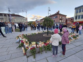 FILE - People gather around flowers and candles after a man killed several people on Wednesday afternoon, in Kongsberg, Norway, Thursday, Oct. 14, 2021. A man was Friday, June 24, 2022 found guilty to murder and attempted murder for fatally stabbing five and wounding four others in southern Norway when he attacked strangers with a bow and arrows and knives.