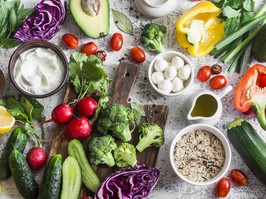 Balanced healthy diet food background in a Mediterranean style. Fresh vegetables, wild rice, fresh yogurt and goat cheese on a light background, top view. Flat lay