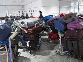 Ein Passagier sucht am 29. Juni 2022 am Flughafen Pierre Elliott Trudeau in Montreal unter einem Stapel nicht abgeholten Gepäcks nach seinem Gepäck.