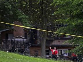 Fire officials look over the scene of a fatal house explosion on Friday, June 17, 2022, in northern St. Louis County just west of Spanish Lake, Mo.