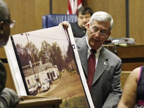 FILE - Prosecutor Doug Evans holds a photo during a trial for Curtis Flowers in court on June 14, 2010, in Greenwood, Miss. A federal appeals court on Thursday, June 16, 2022, affirmed the dismissal of a lawsuit that civil rights advocates filed against Evans. The 2019 lawsuit said Evans routinely rejected Black jurors in criminal cases because of their race, and it sought a declaration that Evans' jury-selection practices violated prospective jurors' constitutional rights. The appeals court ruled the plaintiffs lacked legal standing because they didn't show an "immediate threat" that Evans could strike them from jury service.