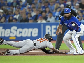 Baltimore Orioles centre-fielder Cedric Mullins (31) slides back into first base as Toronto Blue Jays first baseman Vladimir Guerrero Jr. (27) waits for the throw during first inning American League baseball action in Toronto on Thursday, June 16, 2022.